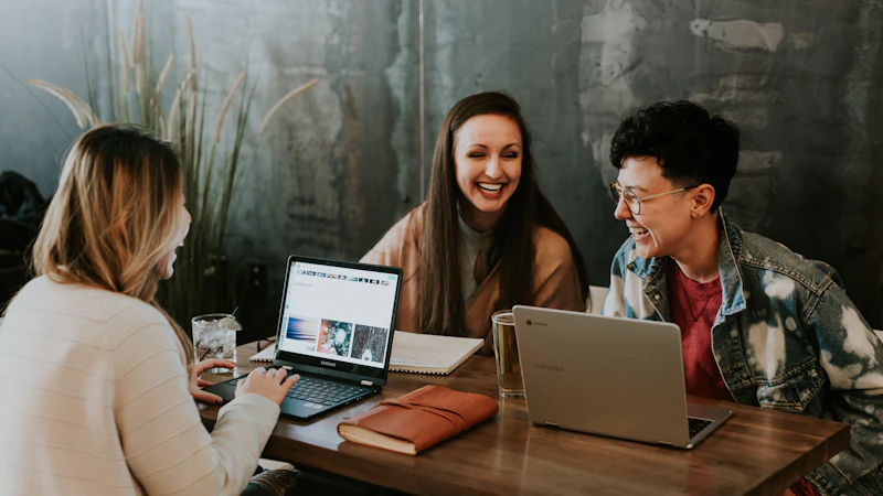 Tres personas conversando en inglés alrededor de una mesa